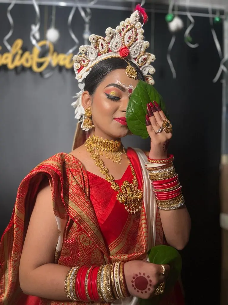 Bengali bride holding paan(beetel leave) in hand in front of a face